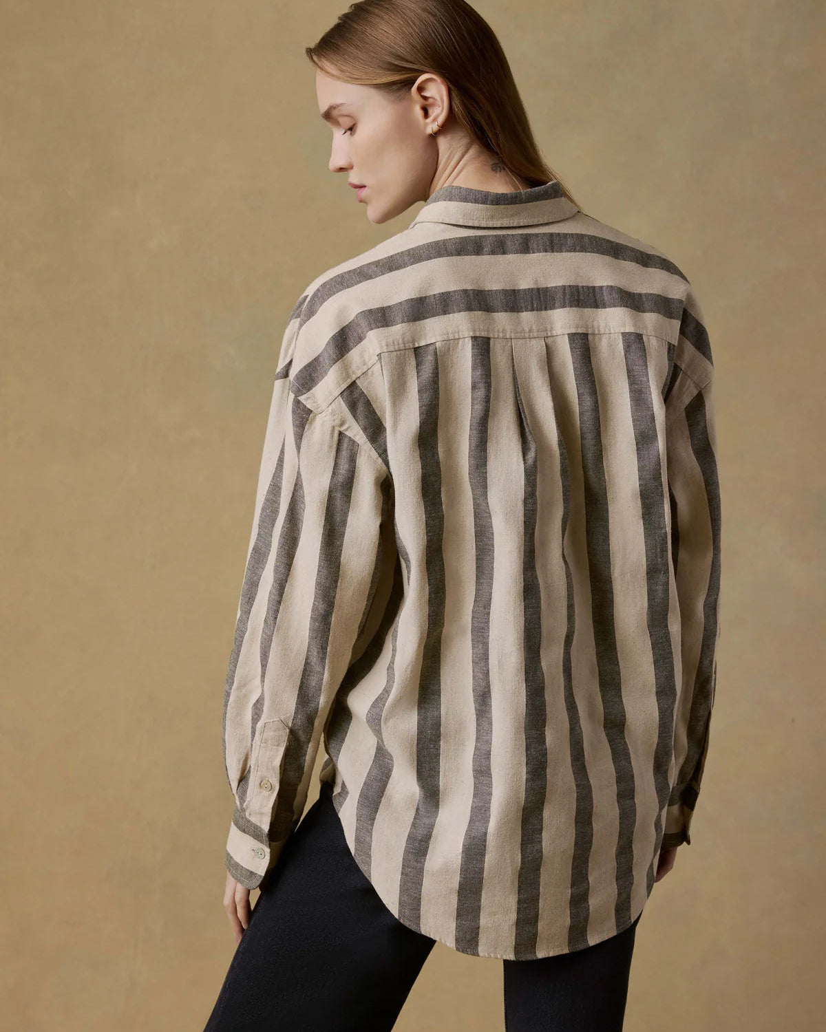 Person wearing a striped shirt against a beige background