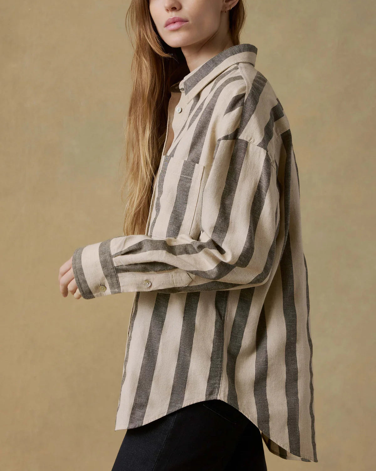 Woman wearing a striped shirt against a beige background