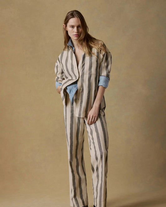 Woman wearing a striped outfit against a beige background