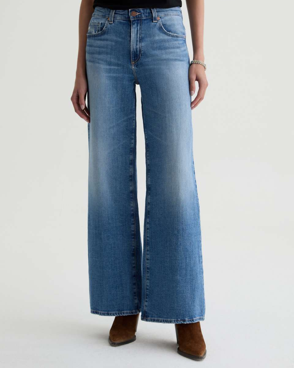 Blue jeans worn by a person on a light gray background