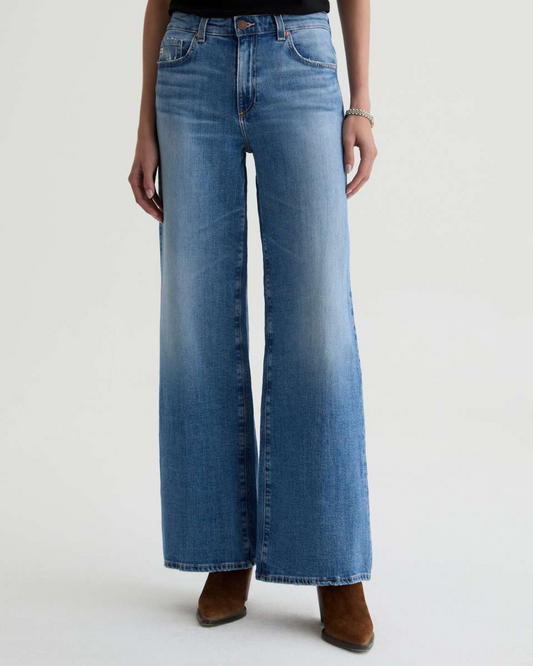 Blue jeans worn by a person on a light gray background