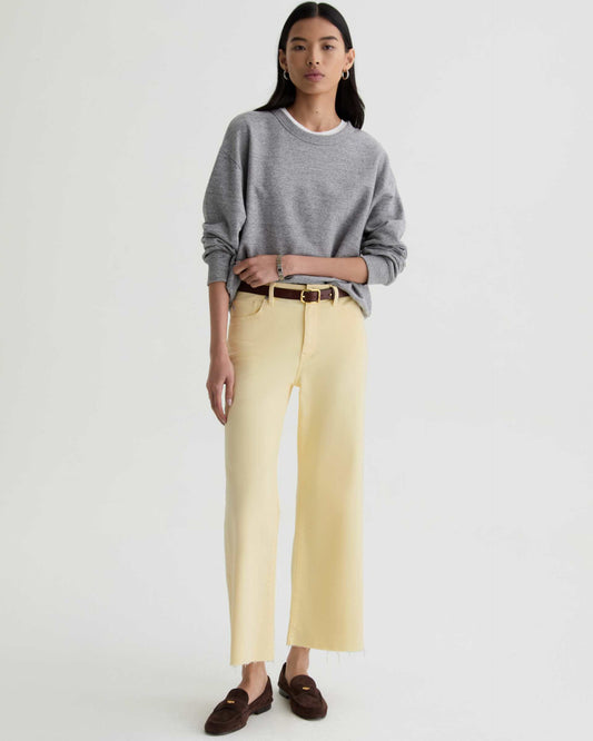 Woman wearing a gray sweater and yellow pants on a white background