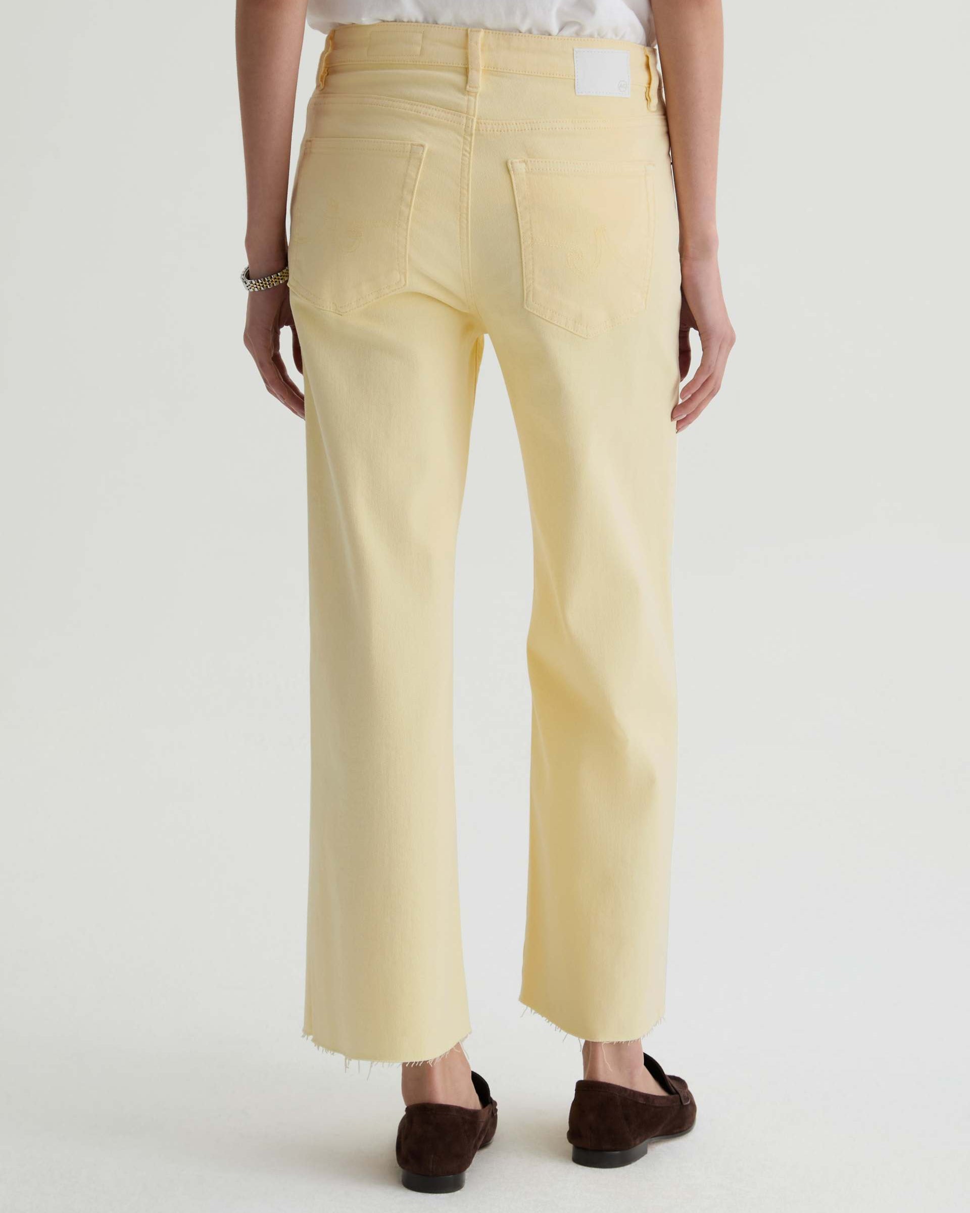 Person wearing light yellow pants on a white background