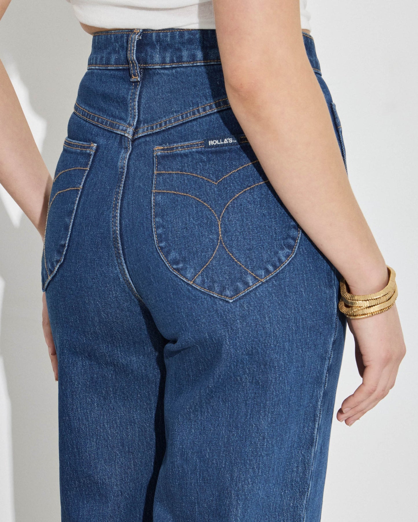 Blue jeans worn by a person on a white background