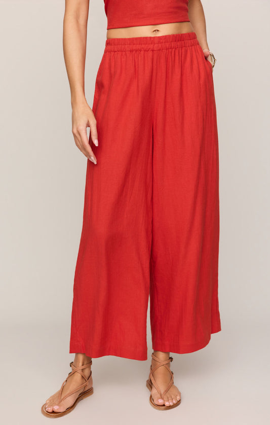 Person wearing red wide-leg pants on a plain background