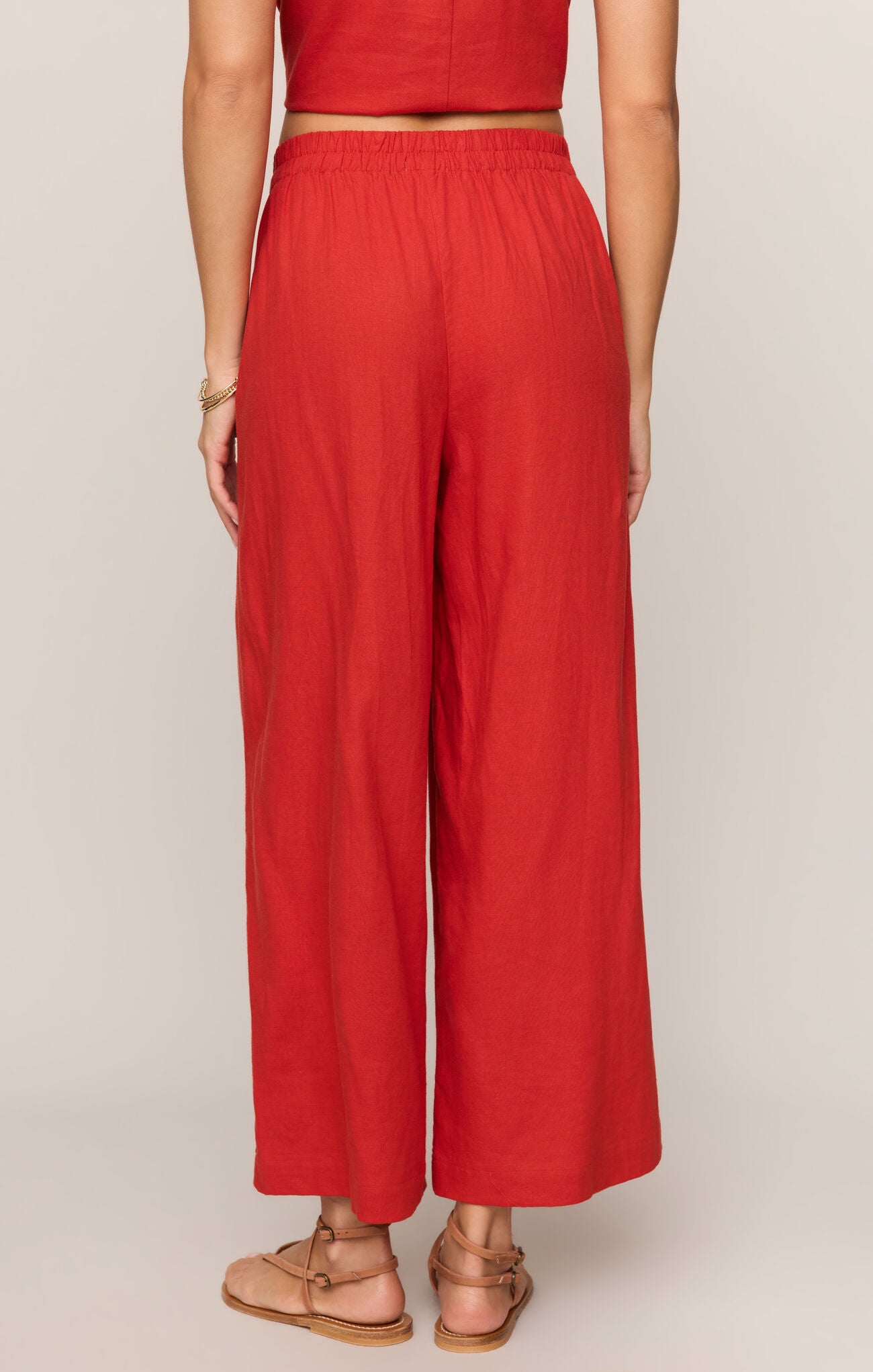 Person wearing red wide-leg pants on a plain background