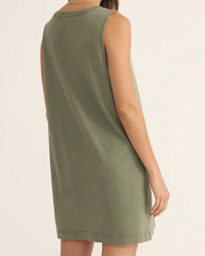 Woman wearing a green sleeveless dress on a plain background