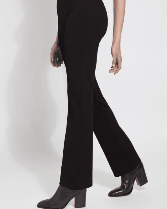 Person wearing black high-waisted pants and black boots on a white background
