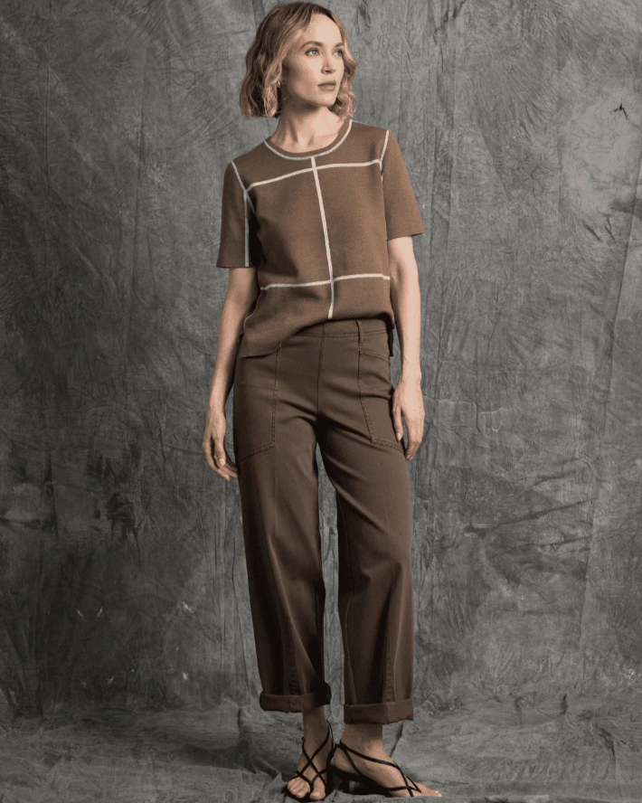 Woman wearing a brown outfit against a textured gray background