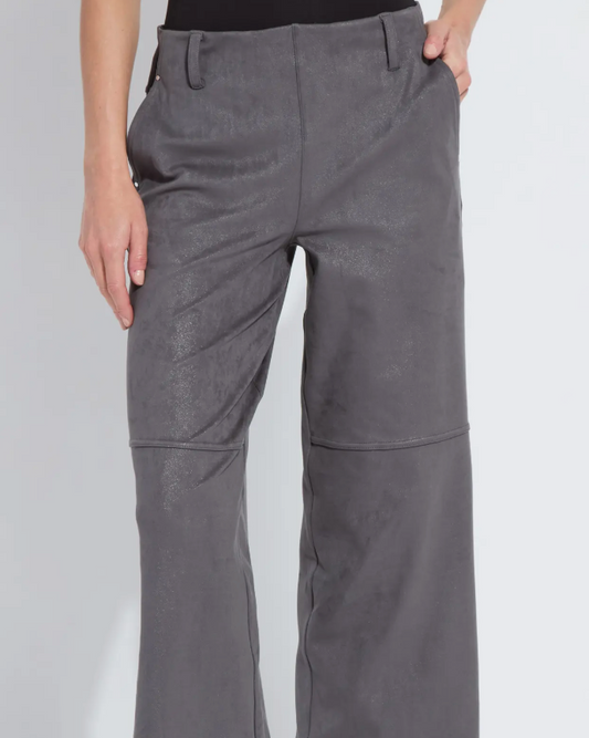 Person wearing gray wide-leg pants and black boots on a white background