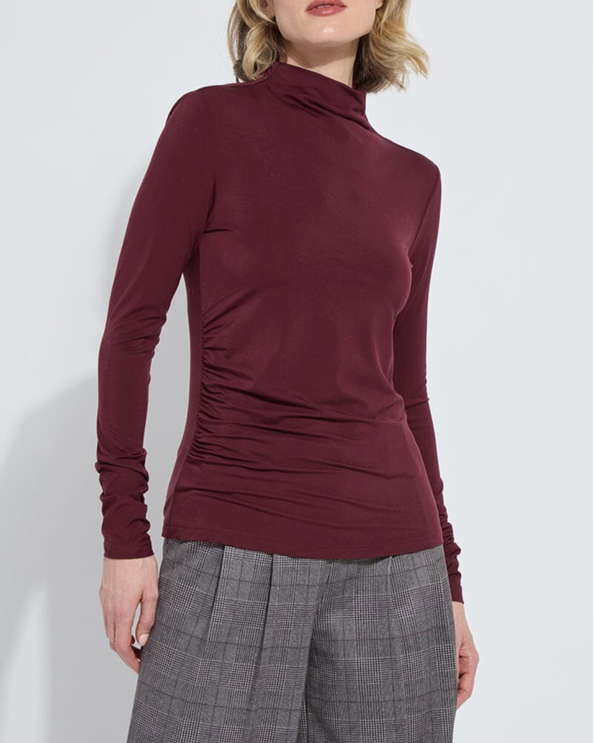 Maroon long-sleeve top worn by a person on a white background