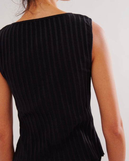 Black pleated dress worn by a person on a plain background