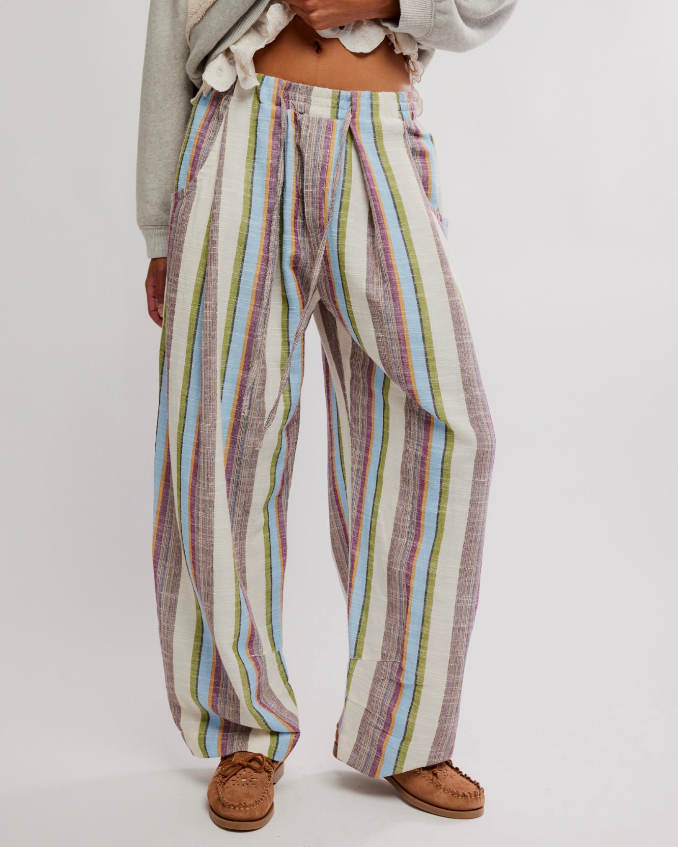 Person wearing colorful striped pants on a plain background