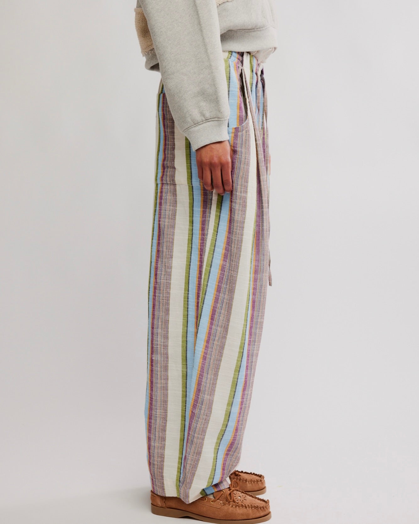 Person wearing colorful striped pants on a plain background