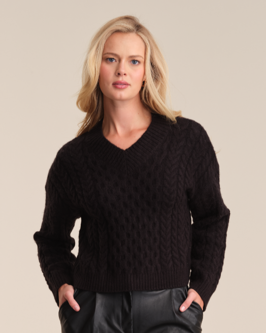 Model is wearing 525 America LEONA CABLE HIGH V-NECK PULLOVER in color black. 