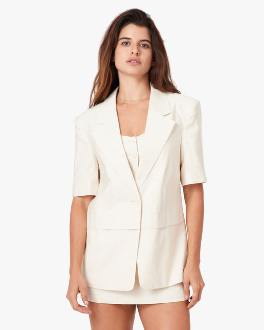 Woman wearing a white blazer and skirt set on a white background
