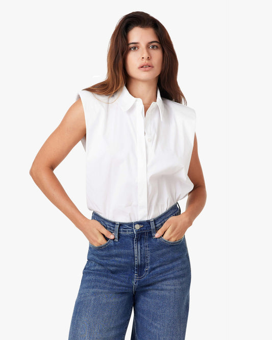 Woman wearing a white sleeveless blouse and blue jeans on a white background