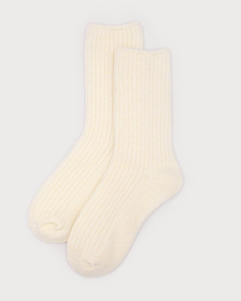 A pair of cream-colored ribbed knit crew socks displayed against a light gray background.