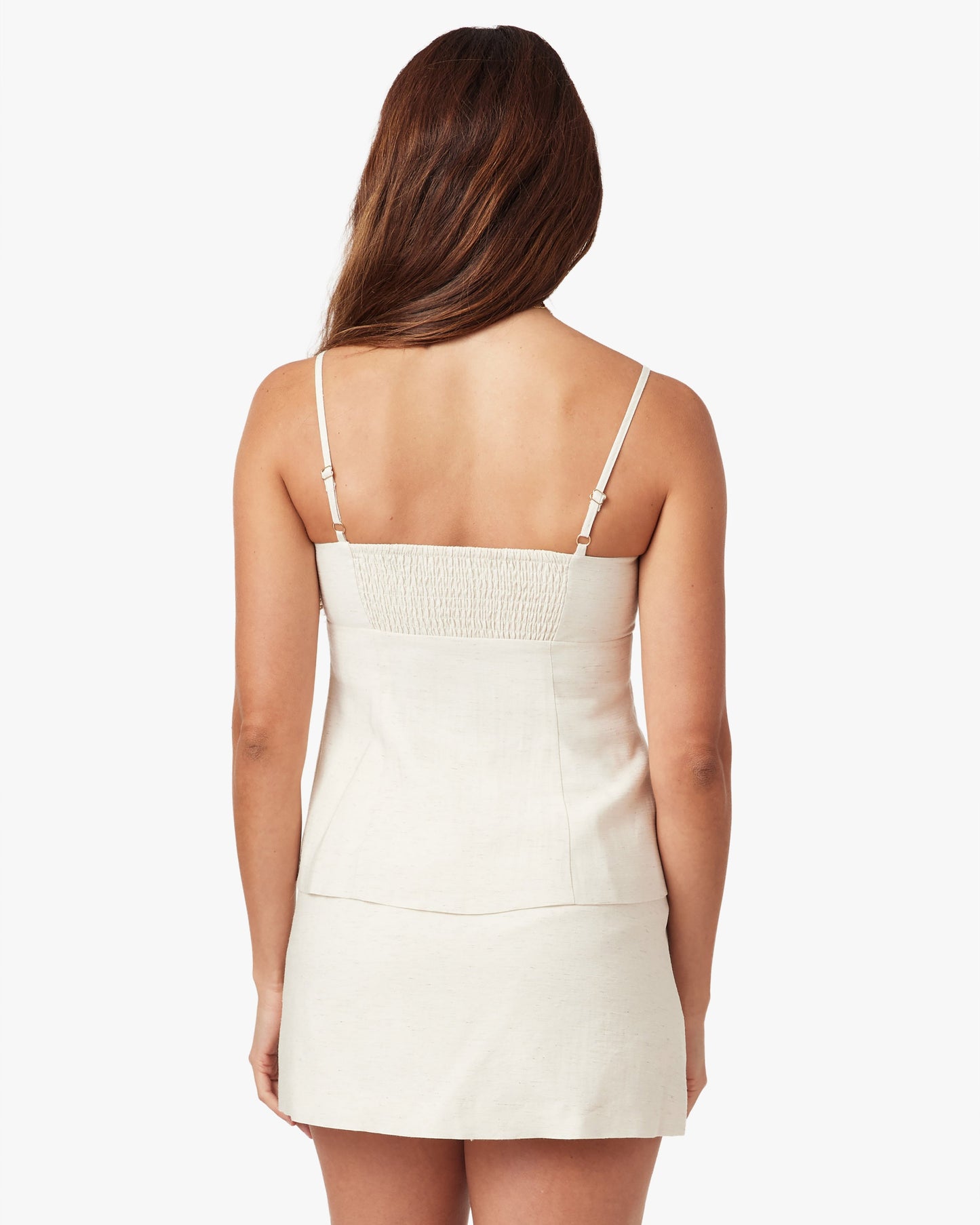 Woman wearing a white dress with thin straps on a white background