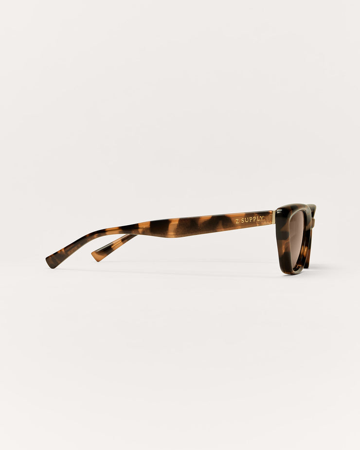 Sunglasses with tortoiseshell frame and dark lenses on a white background