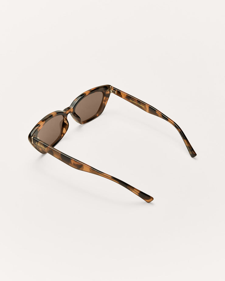 Sunglasses with tortoiseshell frame and brown lenses on a white background