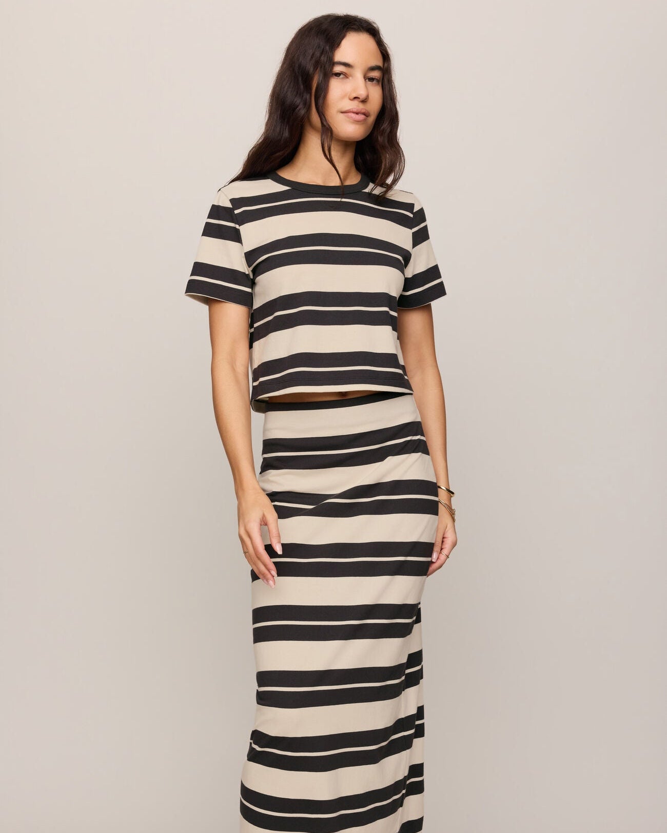 Woman wearing a black and white striped dress on a plain background