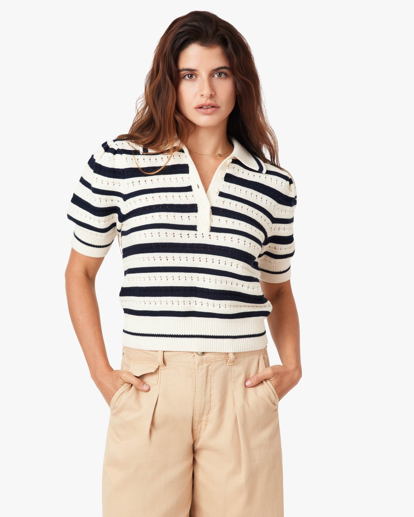 Woman wearing a striped shirt and beige pants on a white background
