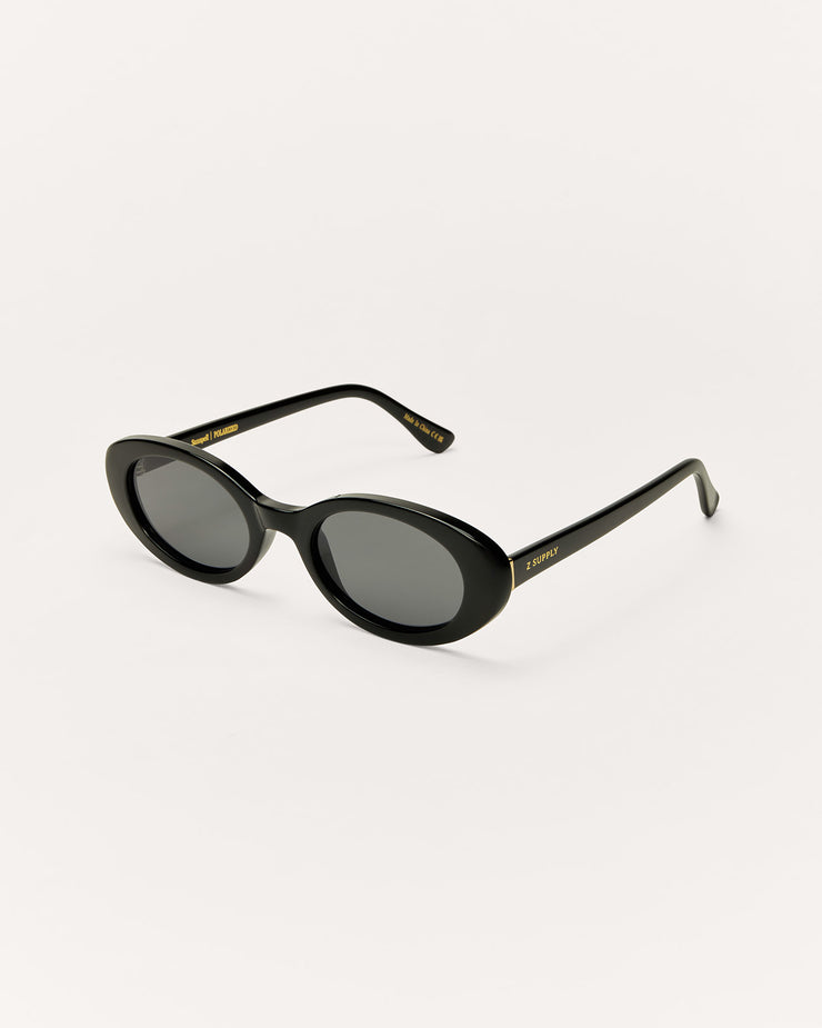 Sunglasses with dark lenses and thin frame on a beige background