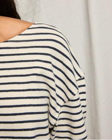 Close-up of a person wearing a striped shirt with a neutral background