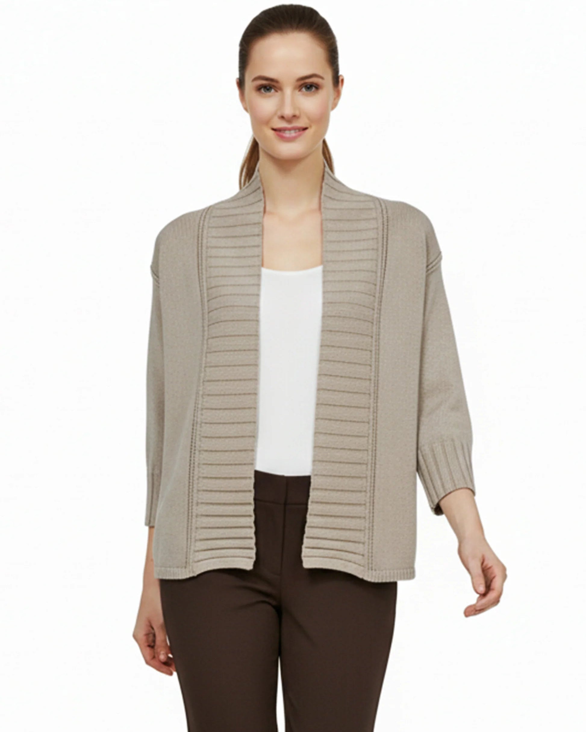 Woman wearing a beige ribbed knit cardigan over a white top and brown pants on a white background