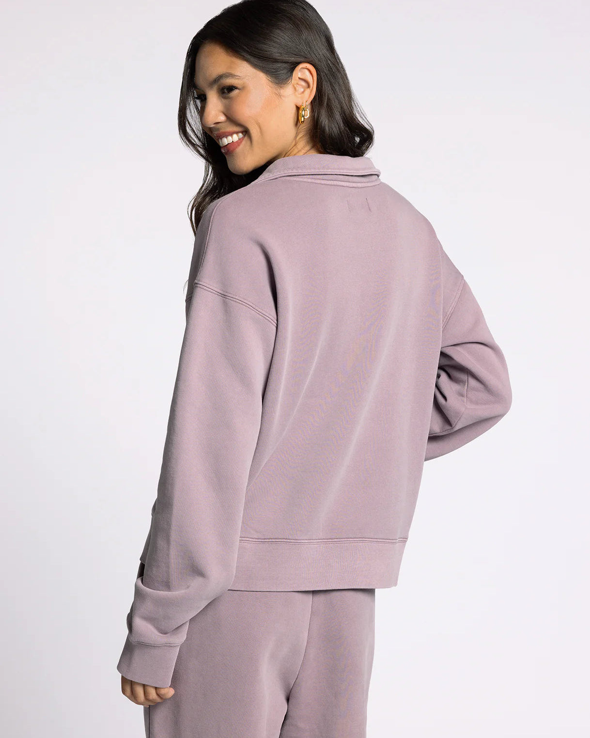 Woman wearing a mauve tracksuit on a white background
