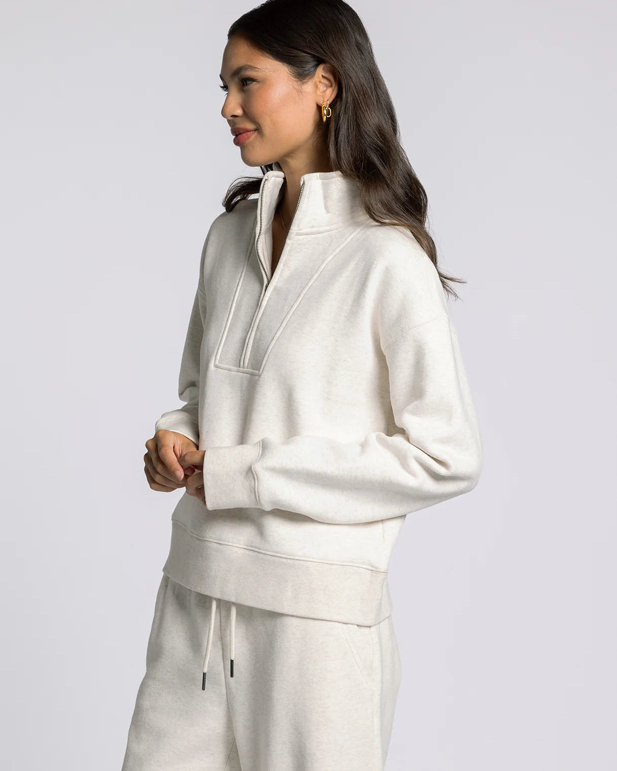 Woman wearing a white tracksuit against a light gray background