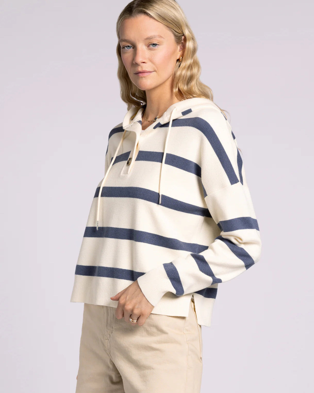 Woman wearing a striped hoodie with a plain background