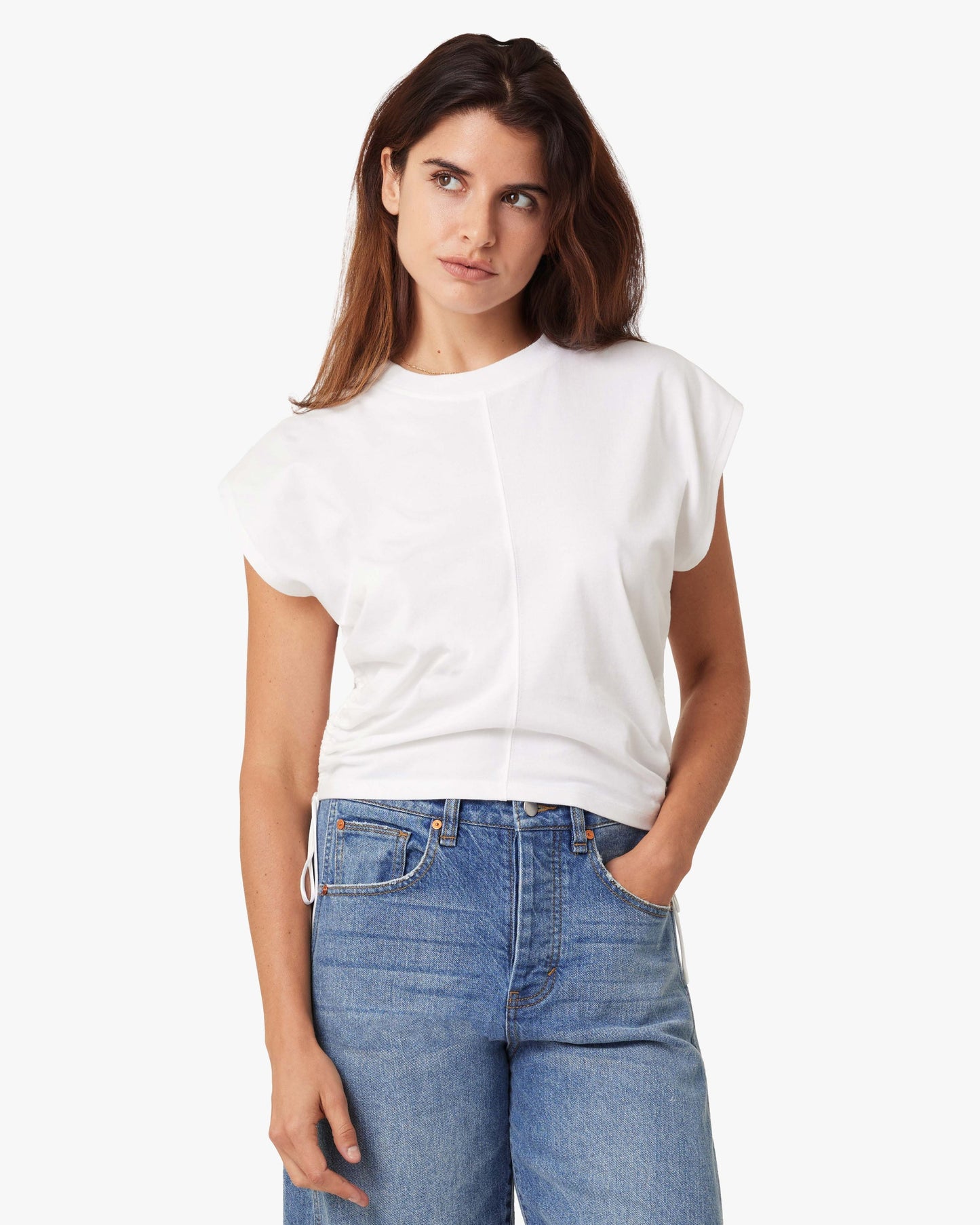 Woman wearing a white t-shirt and blue jeans on a white background