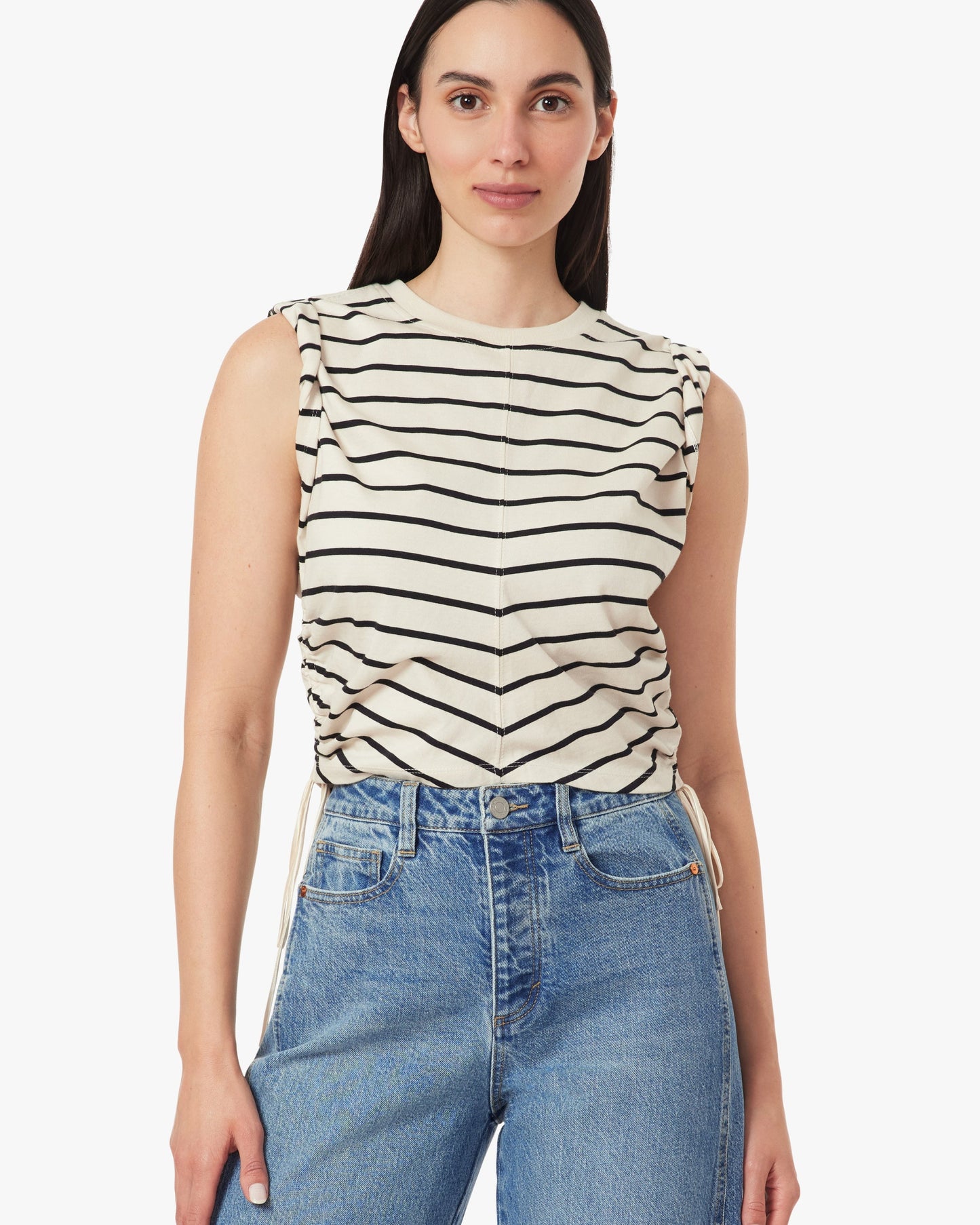 Woman wearing a striped sleeveless top and jeans on a white background