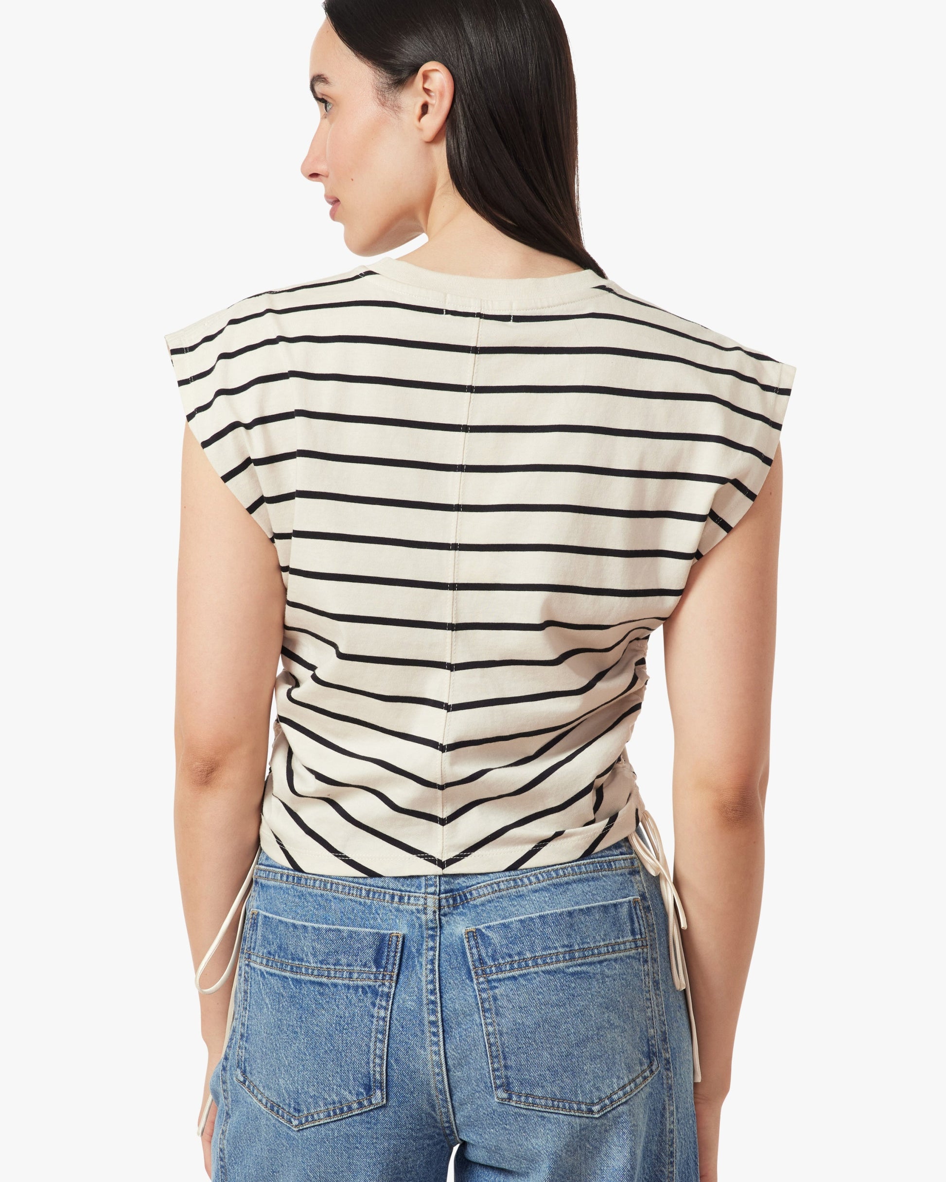 Woman wearing a black and white striped top with a plain background