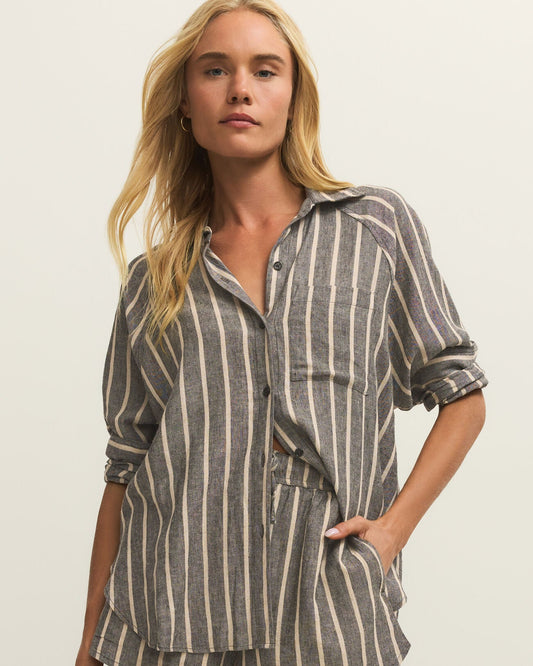 Woman wearing a striped shirt and shorts on a plain background