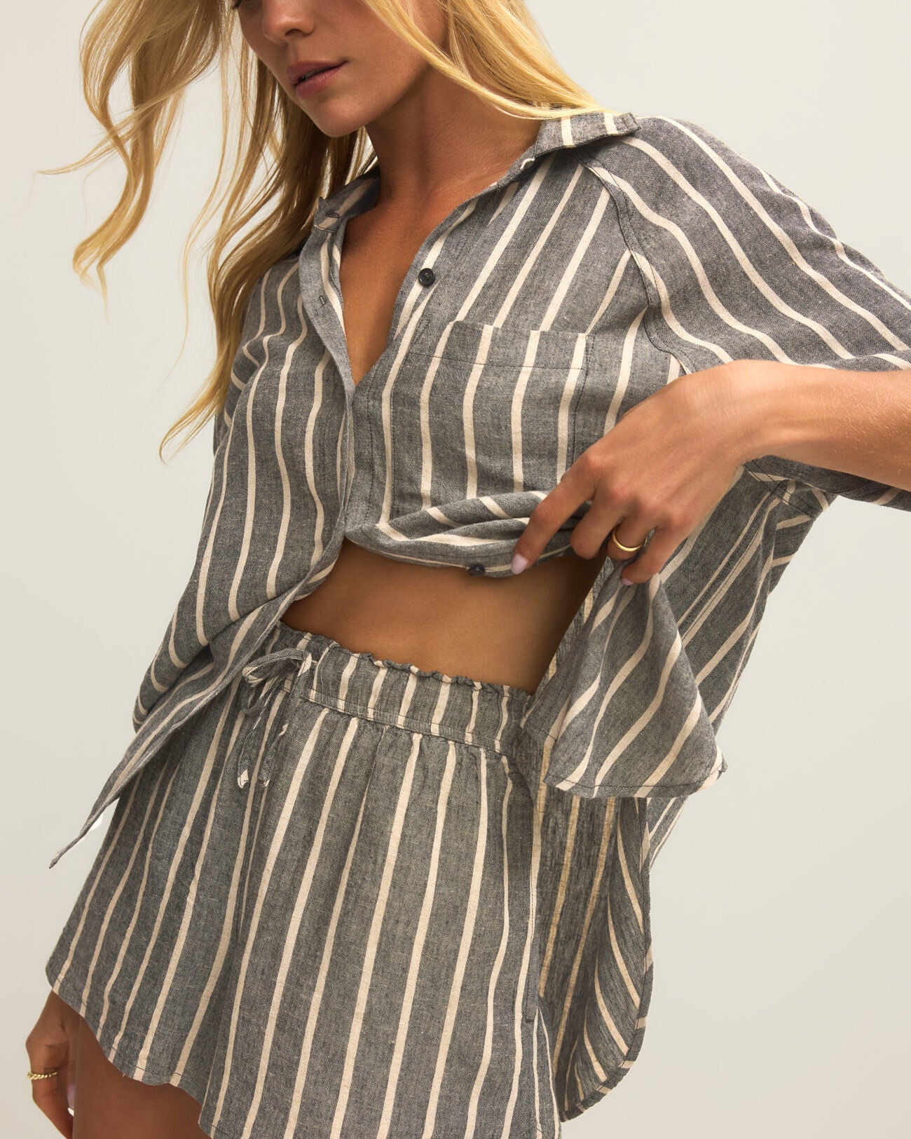 Woman wearing a striped shirt and shorts set on a plain background