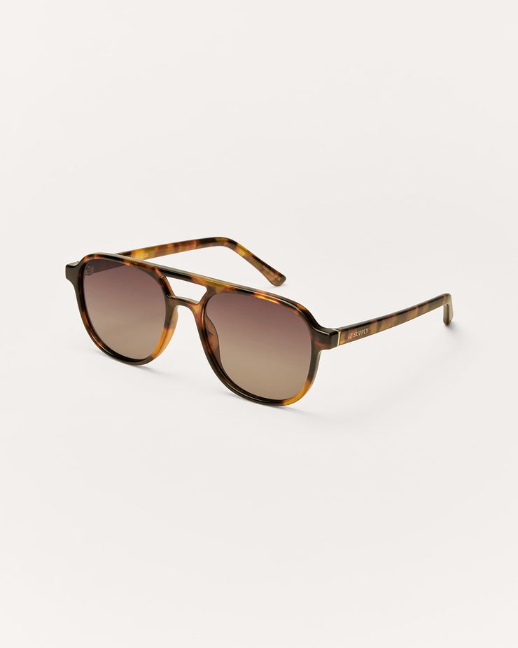 Sunglasses with tortoiseshell frame and gradient lenses on a white background
