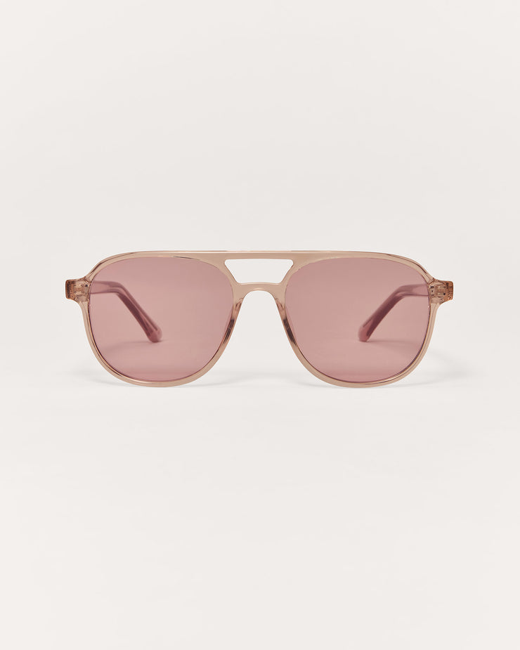 Sunglasses with pink lenses and gold frame on a white background