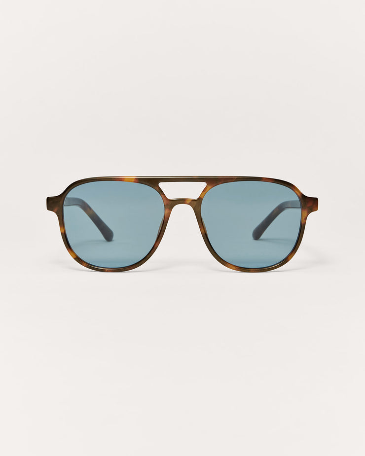 Sunglasses with a tortoiseshell frame and blue lenses on a white background