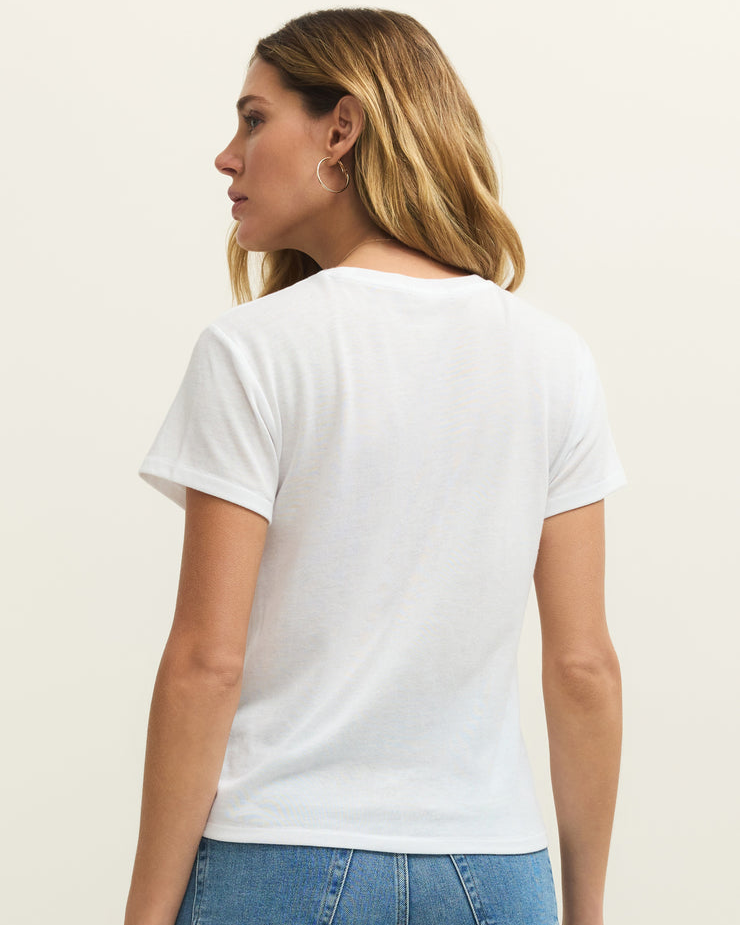 Woman wearing a plain white t-shirt and blue jeans on a light beige background
