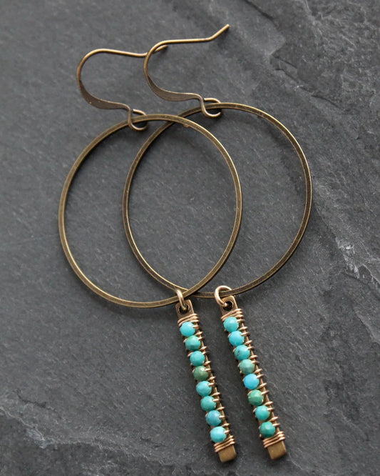 Front view of the Wild Balance Telluride Earring in Turquoise resting on a stone background