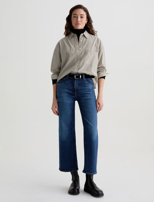 Person wearing a striped shirt, blue jeans, and black boots on a white background