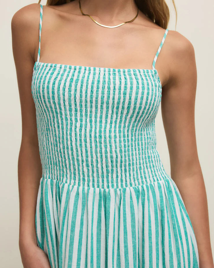 Green and white striped dress worn by a person on a neutral background