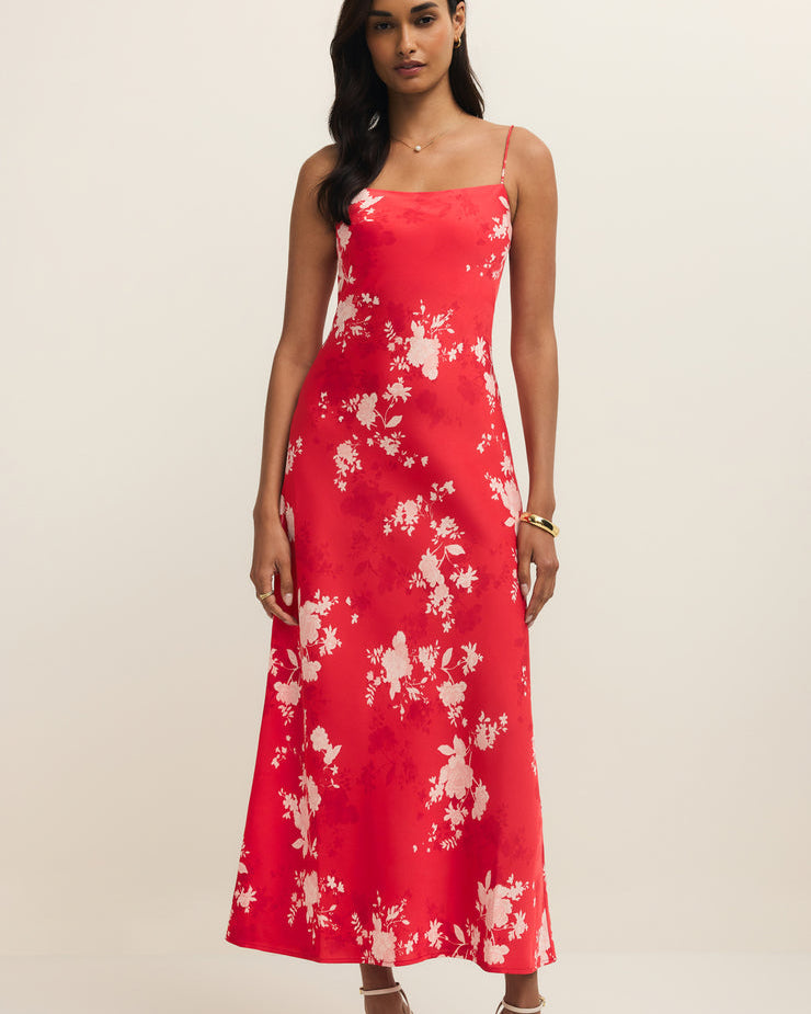 Woman wearing a red floral dress on a beige background