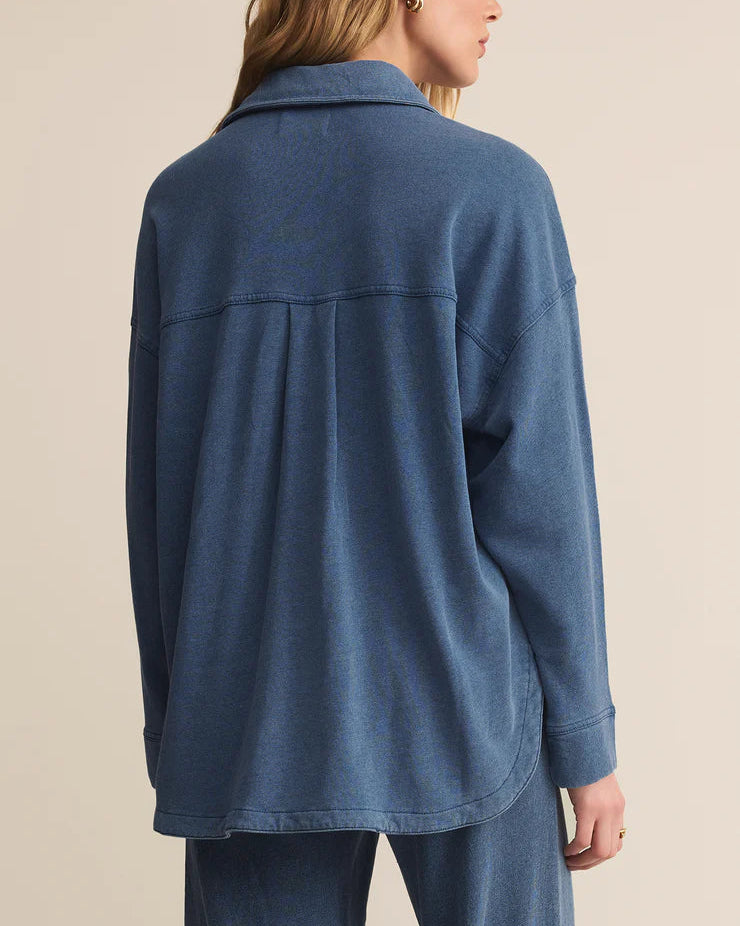 Woman wearing a blue jacket on a beige background