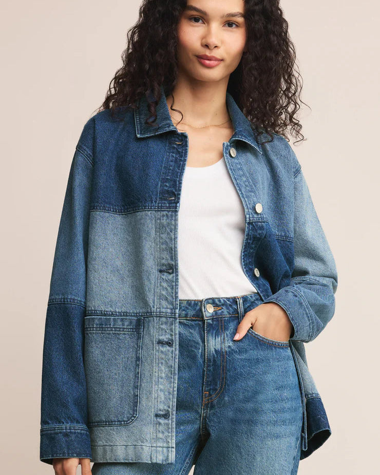 Woman wearing a denim jacket and jeans on a beige background