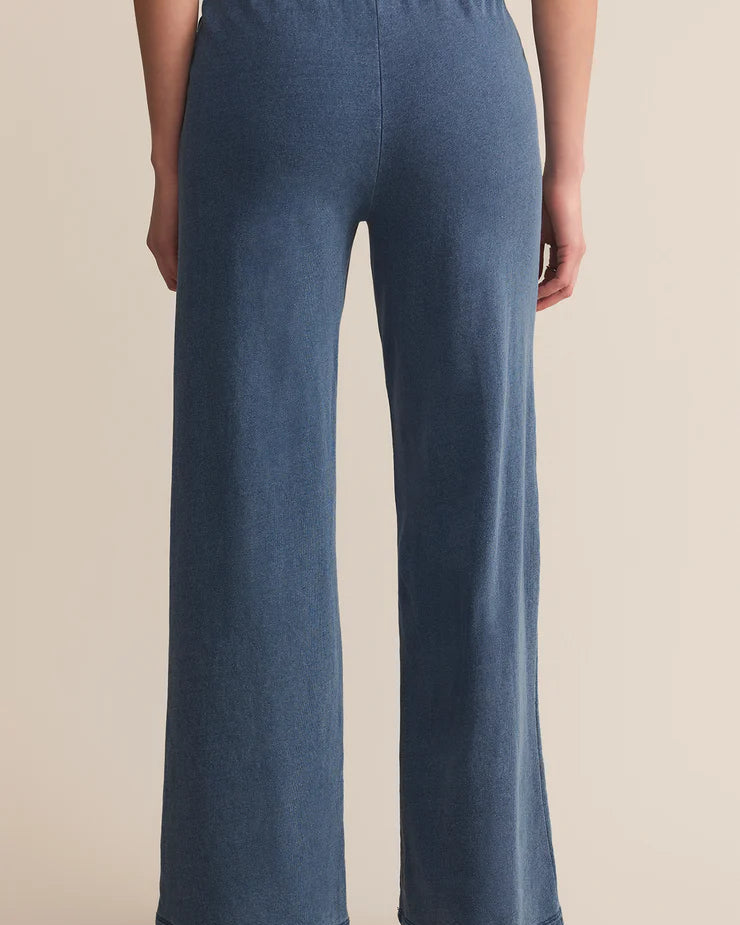 Blue terry pants worn by a person on a beige background