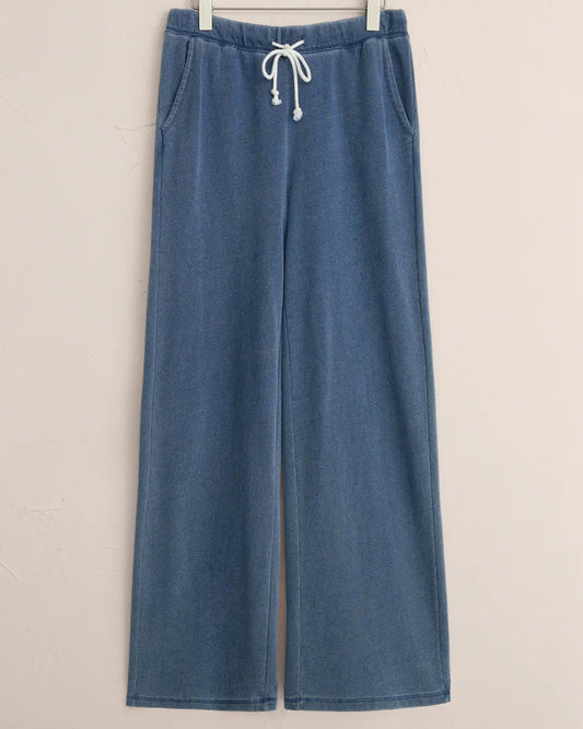 Blue wide-leg pants with a drawstring on a hanger against a beige background